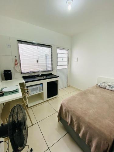 a bedroom with a bed and a desk and a window at DuPai 8 Sorocaba in Sorocaba