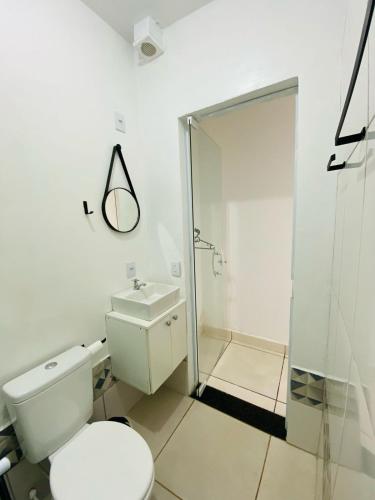 a white bathroom with a toilet and a shower at DuPai 8 Sorocaba in Sorocaba