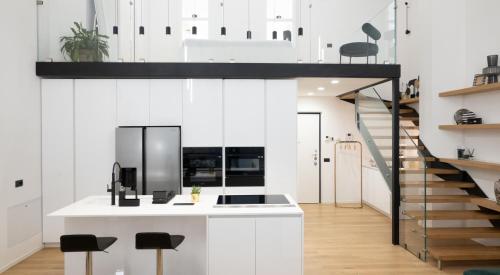 a kitchen with white walls and a stair case at Loft Milano Manifatture2 in Milan