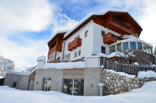 a house in the snow with snow at Hotel Chalet Dlaces in Selva di Val Gardena