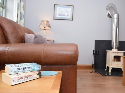 a living room with a leather couch and a wood stove at 1 Bed in Durham HISHO in Lanchester