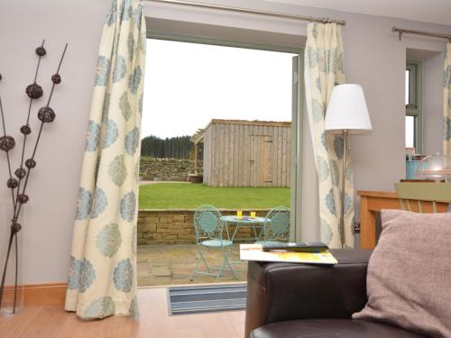 a living room with a couch and a sliding glass door at 1 Bed in Durham HISHO in Lanchester