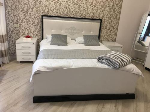 1 cama blanca grande en un dormitorio con pared en Guesthouse in Historic Village, en Aghtsʼkʼ