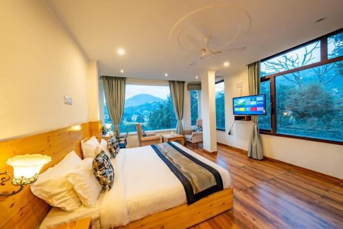 a bedroom with a large bed and a large window at The Himalayan Stays Nainital in Nainital
