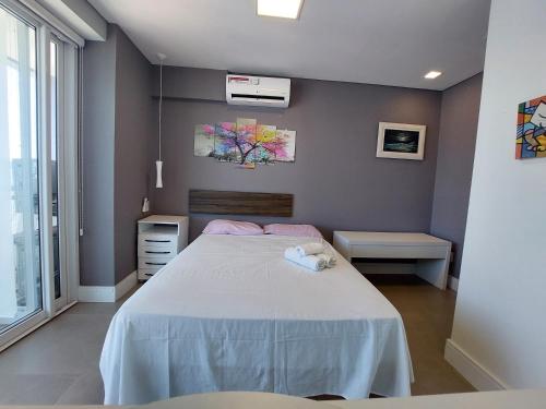 Un dormitorio con una cama grande y una ventana. en Book Santos – Unlimited 3111 - Decoração e Vista mar TOP, en Santos