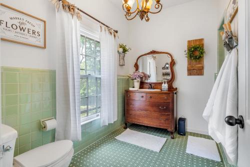 a bathroom with a sink and a toilet and a mirror at Grand Mansion-Blooming Garden suite! in Fort Smith