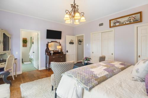 フォートスミスにあるGrand Mansion-Blooming Garden suite!のベッドルーム1室(ベッド1台、デスク、ドレッサー付)