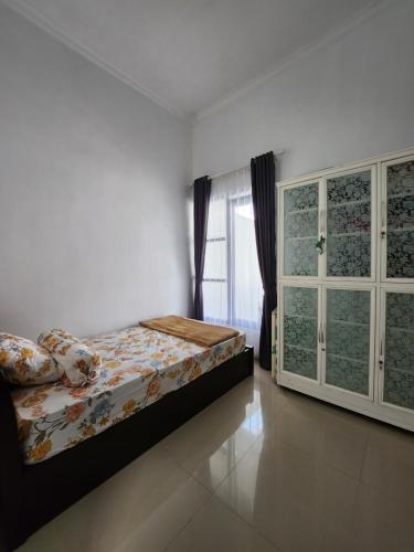 a bedroom with a bed and a window at Villa Jingga Joyogrand Malang in Malang