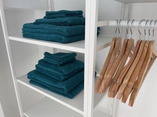a white closet with green towels and wooden utensils at Luxury 2 Bed Apartment in Portadown