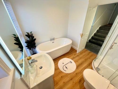 a bathroom with a tub and a toilet and a sink at Luxury 2 Bed Apartment in Portadown