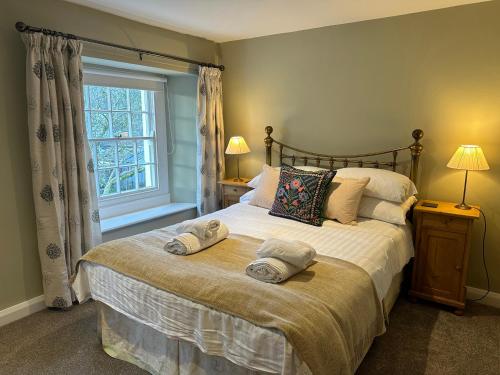a bedroom with a large bed with towels on it at Croft End Cottage in Sawrey