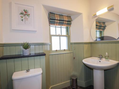 a bathroom with a toilet and a sink at Glen Cottage - Torridon in Achnasheen