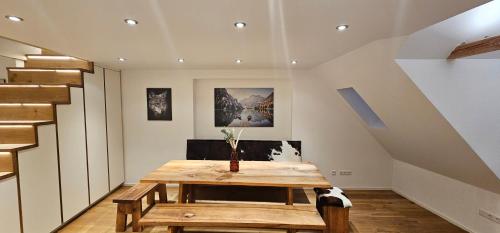 ein Esszimmer mit einem Holztisch und einer Treppe in der Unterkunft Apartments Pfannenstübchen in Meersburg