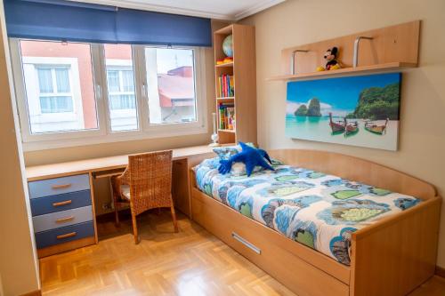 a bedroom with a bed and a desk and a window at Apartamento Mayte in Siero
