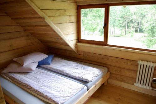 1 cama en una cabaña de madera con ventana en Užukalnio sodyba, 