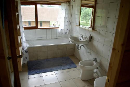 y baño con bañera, lavabo y aseo. en Užukalnio sodyba, 