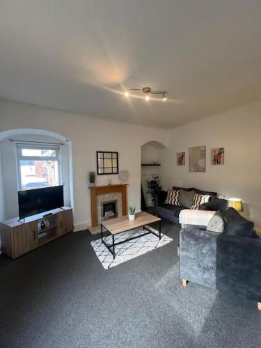 a living room with a couch and a fireplace at Comfortable and spacious home. FREE Parking. in Gateshead
