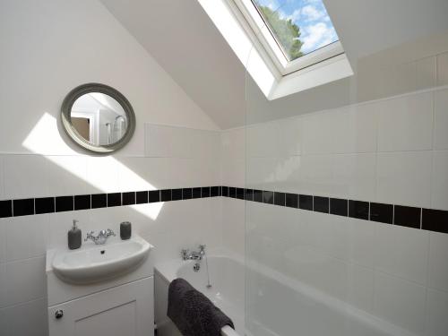 bagno bianco con lavandino e specchio di 5 Bed in Conwy 48169 a Eglwys-Fâch