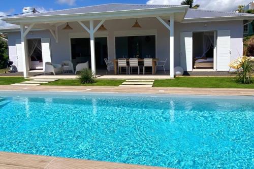 a swimming pool in front of a house at Villa du Levant-6/8 pers-Piscine in Saint-François