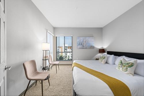 ロサンゼルスにあるVenice Beach Lux Retreat Coastal Apartment Havenのベッドと椅子付きのホテルルーム