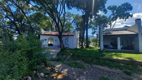 una casa blanca con árboles delante de ella en La Justina - Casa de Campo en San Lorenzo en San Lorenzo