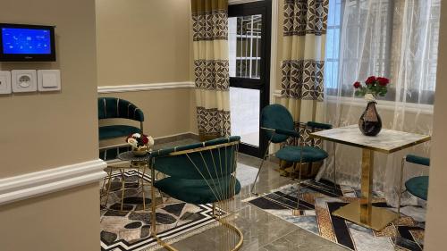 a room with green chairs and a table and a window at JPN SQUARE Douala in Douala