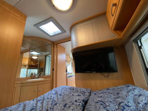 a bedroom with a bed and a flat screen tv at Röhrencamp Schöten/Apolda in Apolda