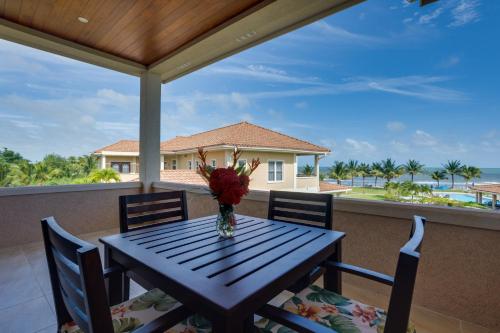 a table with chairs and a vase of flowers on a balcony at Seiri del Mar in Hopkins