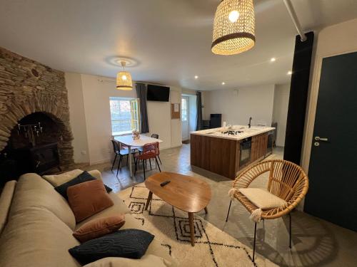 a living room with a couch and a table and a kitchen at Maison de caractère, centre ville historique in Malestroit