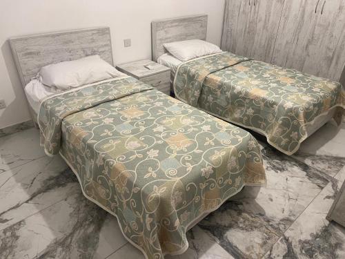 twee bedden naast elkaar in een kamer bij Maisonette 2 in Munxar