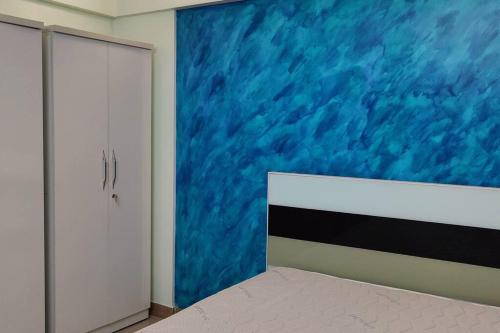 een slaapkamer met een blauw schilderij aan de muur bij Luxurious 3BHK Flat in Magarpatta in Pune