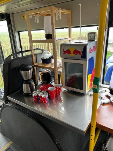 a table with a microwave and cups on it at Röhrencamp Schöten/Apolda in Apolda