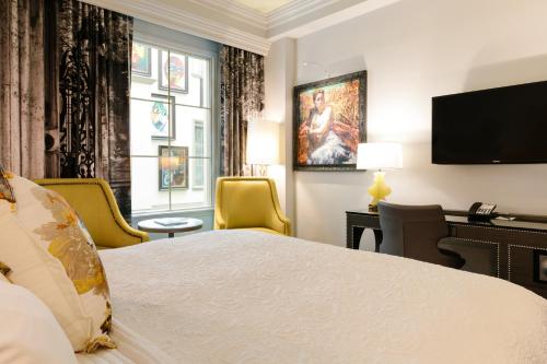 een hotelkamer met een bed, een bureau en een televisie bij Grand Bohemian Hotel Charleston, Autograph Collection in Charleston