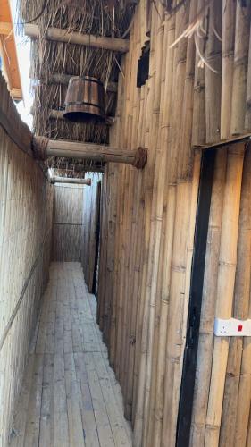 un couloir vide dans un bâtiment aux murs en bois dans l'établissement اكواخ البامبو, à Malham
