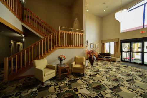 a lobby with a staircase and chairs and a table at Baymont by Wyndham Marion in Marion