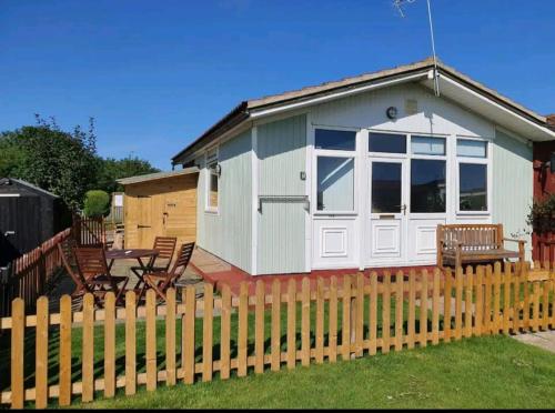 a green and white shed with a fence at The Salty Sea Dog - Dog friendly and 2 minutes walk to the beautiful, golden beach in Bridlington