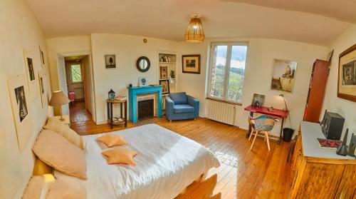 une chambre avec un grand lit et une chaise bleue dans l'établissement Charmant presbytère en Basse-Normandie, à Crouttes