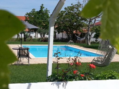 a swimming pool with a hammock in a yard at Casas da Moagem in São Domingos