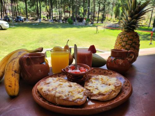 a table topped with a plate of food with pineapple at Rancho San Miguel in Villa del Carbón