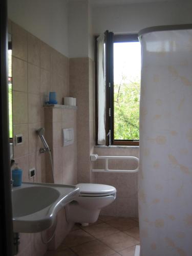 een badkamer met een bad, een toilet en een raam bij Agriturismo Casalino in Beverino