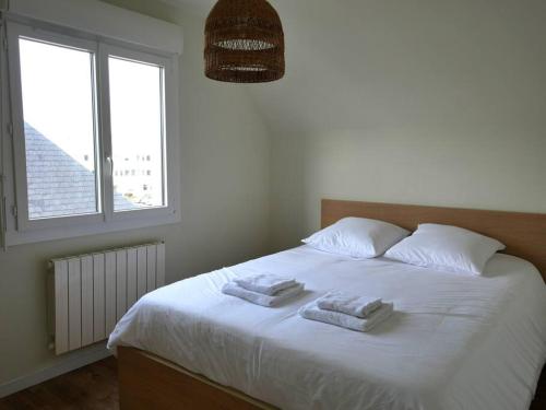 a bedroom with a white bed with two towels on it at CHEZ LEO: T2,cosy,metro in Rennes