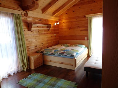 a bedroom with a bed in a log cabin at Ferienhaus Lechnerhof in Schladming