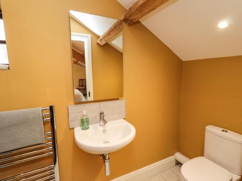 uma casa de banho com um lavatório e um WC em Rustic Lancashire Farmhouse em Preston