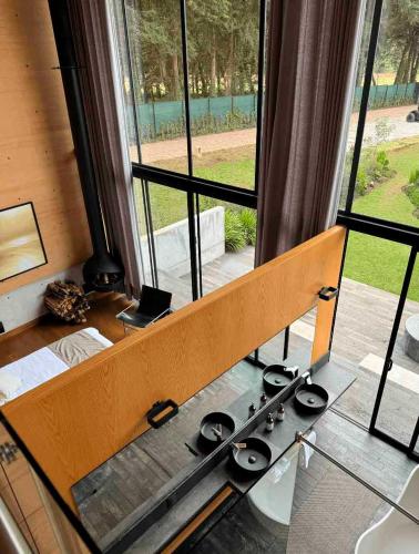 a bed in a room with a large window at Cabañas Avandaro Santo Boutique in Valle de Bravo