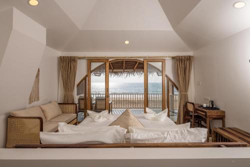 - un salon avec un lit et une vue sur l'océan dans l'établissement The Shore Agonda, à Agonda
