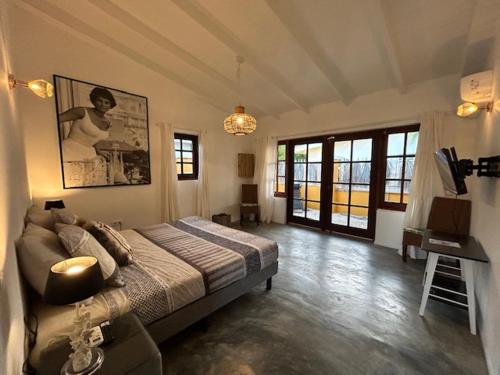 a bedroom with a bed and a table in it at Landhuis Belnem Bonaire in Kralendijk