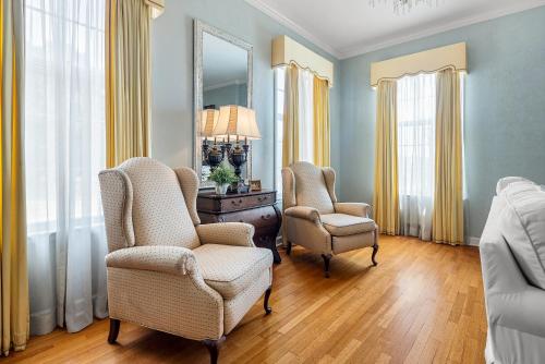 a room with two chairs and a desk and a mirror at Beland Mansion-Blue Jay suite! in Fort Smith