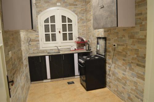 uma cozinha com um lavatório e uma bancada em عقار العرب em Cidade 6 de Outubro