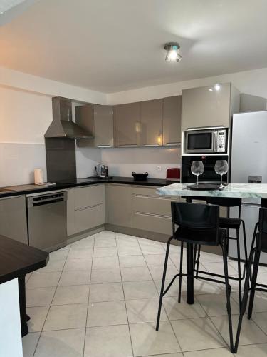 une cuisine avec une table avec des chaises et un micro-ondes dans l'établissement Le cocon Ruellois, à Rueil-Malmaison