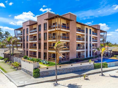 un edificio de apartamentos con piscina y palmeras en Beach front Varandas Do Mar, en Cumbuco
